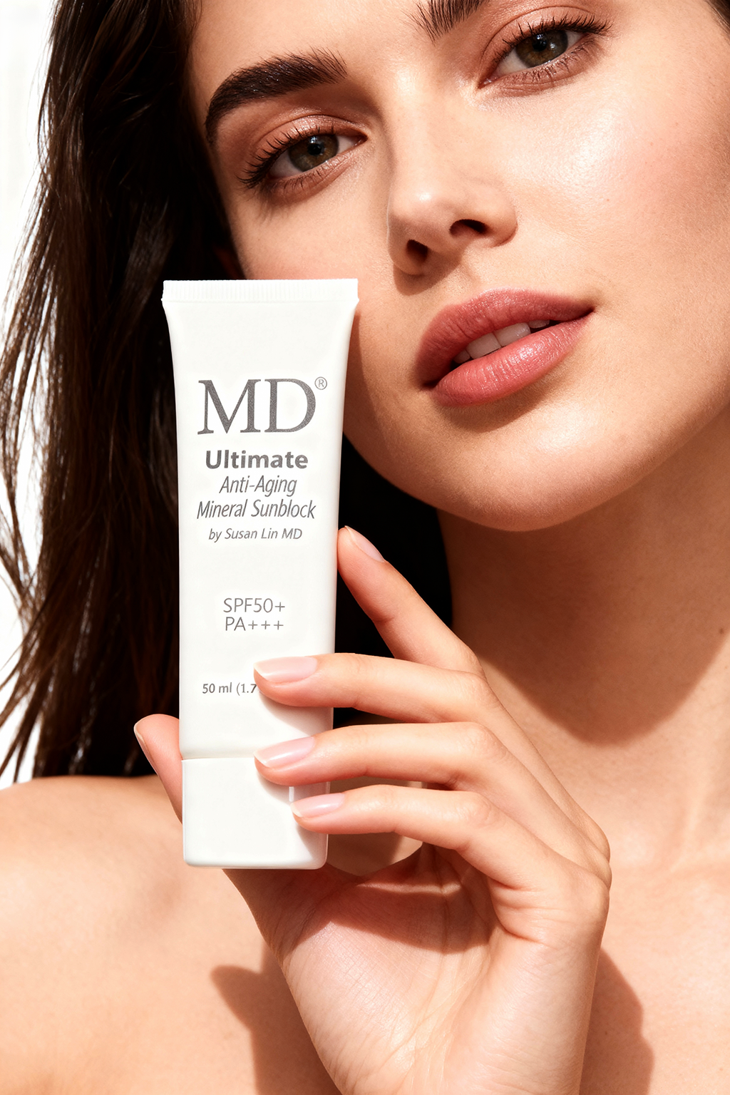 Woman holding MD medical-grade mineral sunblock SPF 50 for broad-spectrum UV and digital blue light protection.